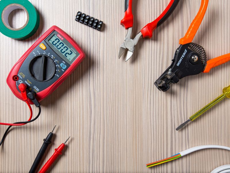 a bunch of electrician's tools are laid out in a circle on a wooden table